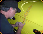 Photo of Casey Kennell pinstriping a custom hotrod